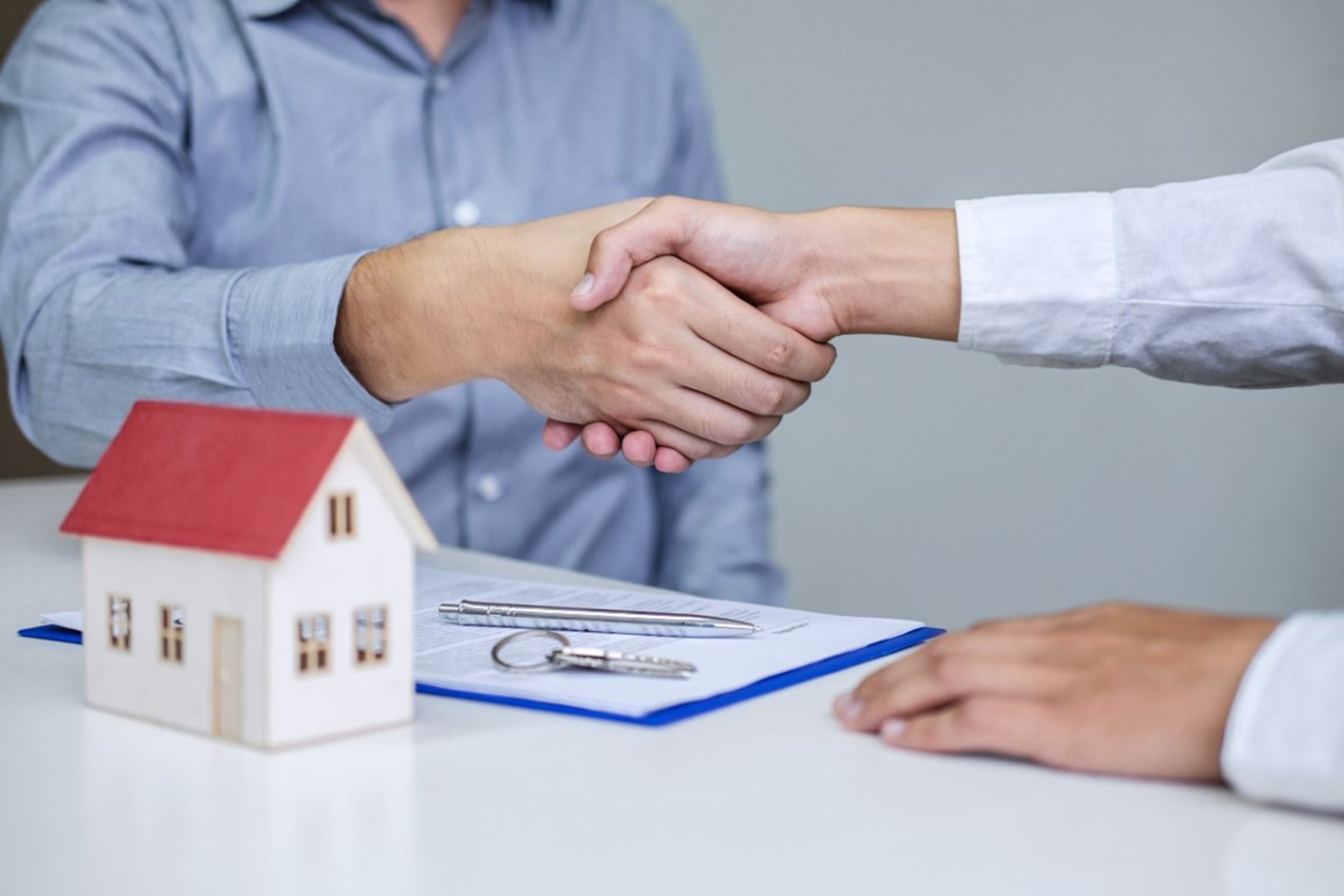 Agente de seguros firmando acuerdo con cliente para seguro del hogar